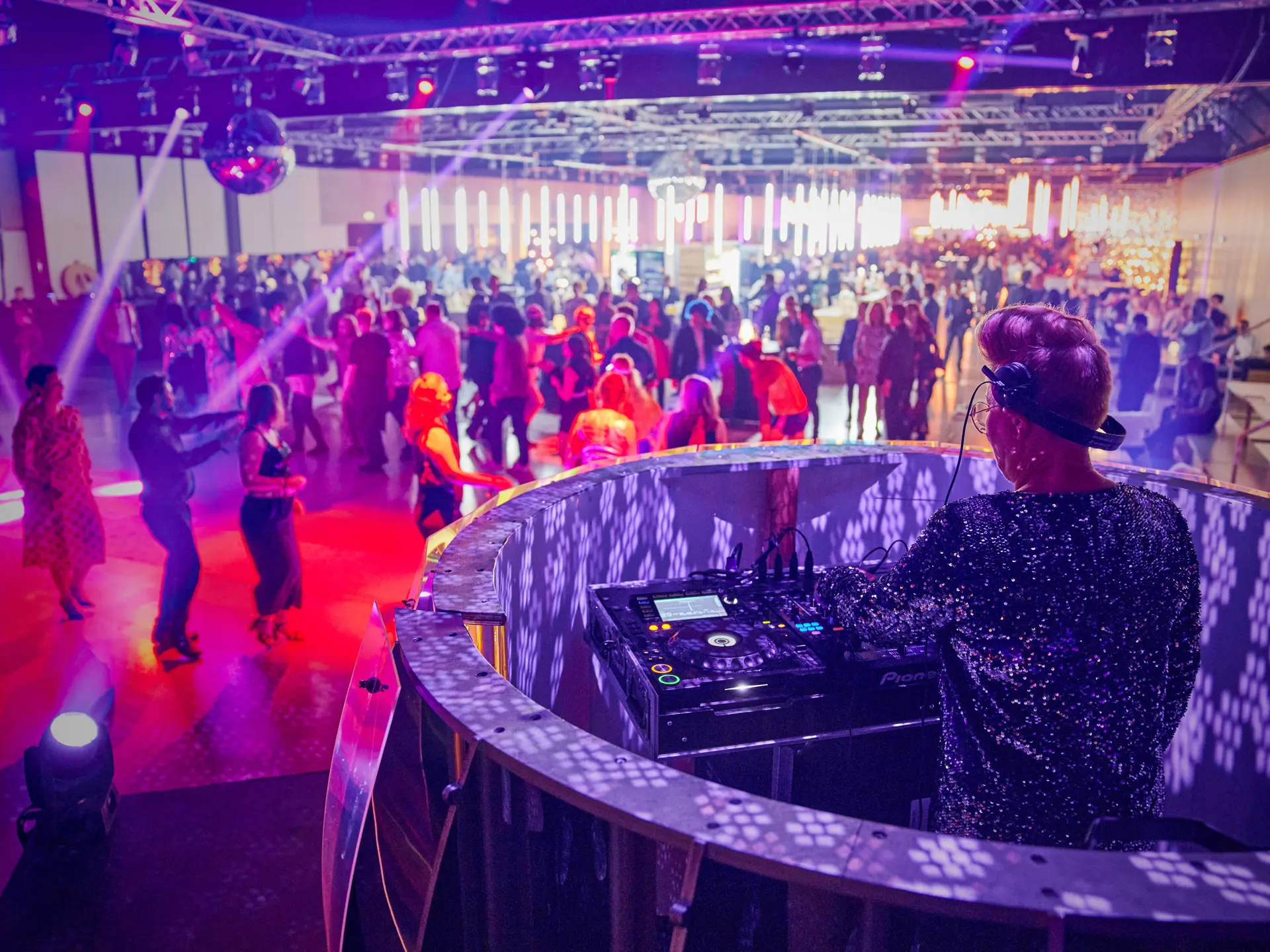 DJ spiller for fyldt dansegulv med farverig lyssætning til julefrokost i Bella Center.