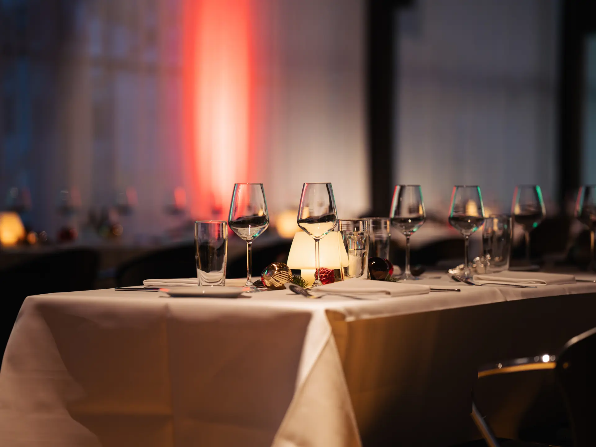 Stemningsfuldt bord med glas, stearinlys og julepynt til julefrokost i Bella Center.