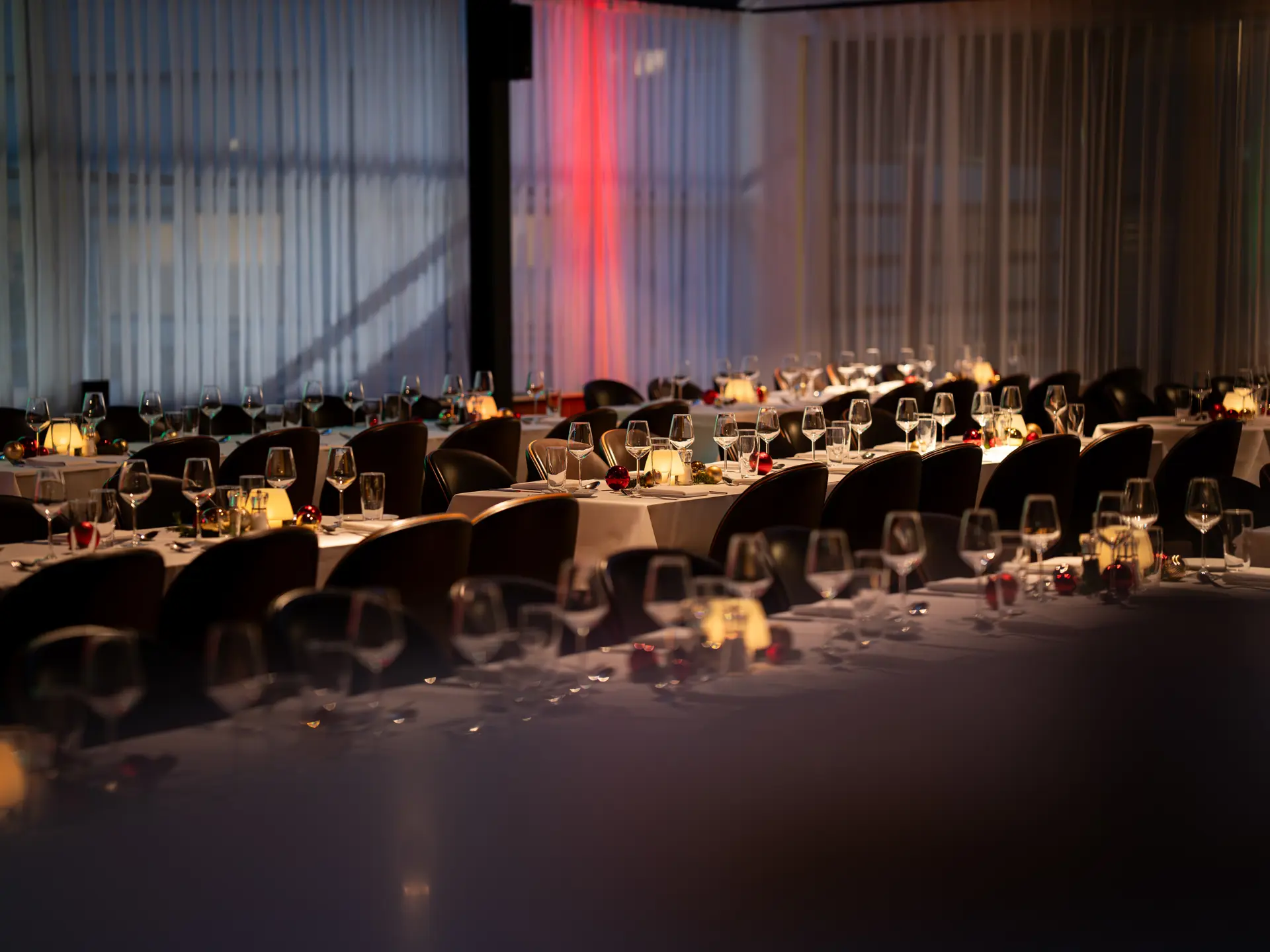 Festopdækkede borde med julepynt og stearinlys til julefrokost i Bella Center.