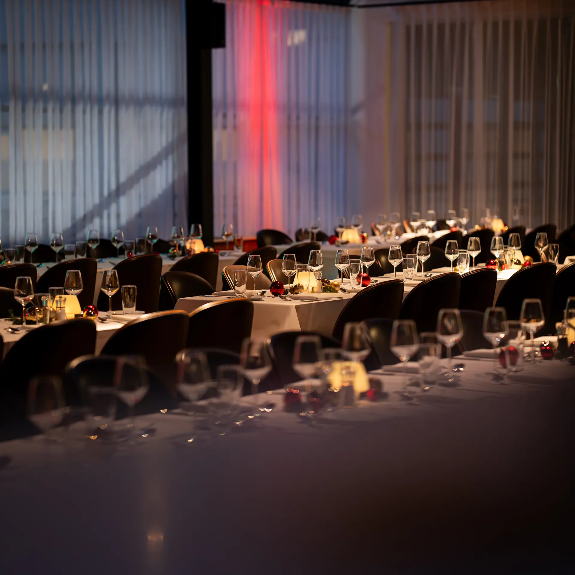 Festopdækkede borde med julepynt og stearinlys til julefrokost i Bella Center.